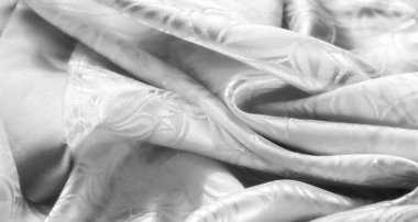 Yaprak desenli yüksek kaliteli beyaz saten kumaş yakın plan, pürüzsüz dokusunu ve karmaşık ayrıntılarını gösteriyor