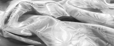 Tekrarlanan yaprak desenli, buruşuk beyaz bir kumaş ve ipeksi bir parıltı. Işık kıvrımları kapatıyor, zarif ve yumuşak bir doku yaratıyor, lüks tekstil ve kumaşlar için mükemmel..