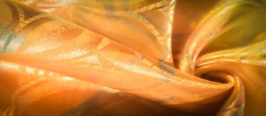 Zarif altın kumaş, çiçekli kabartma desenli, yumuşak ışığı yansıtıyor. Karmaşık kıvrımlar, tekstil ve tasarım projeleri için mükemmel, zengin, lüks bir doku yaratıyor.