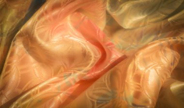 Pürüzsüz ve lüks bir son sunan, altın, şeftali ve pastel tonlarında kıvrımlı çiçek desenli parlak, çok renkli kumaşın yakın çekimi