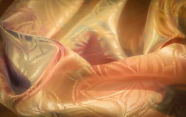 Ilık altın, kehribar ve yeşil tonlarda gösterişli saten kumaş. Karmaşık çiçek desenleri ve ışık yansımaları sergiliyor. Parlak ve zarif bir görünüm yaratıyor..