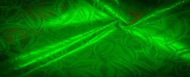 Akan, organik desenli yeşil saten kumaş yumuşak, pürüzsüz kıvrımlar göstermek için kırışmış, canlı ve dinamik bir görsel efekt yaratıyor.