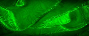 Yumuşak kıvrımlar ve parlak dokularla vurgulanmış, karmaşık çiçek ve yaprak desenli soyut bir yeşil kumaş görüntüsü.