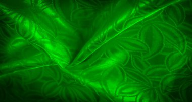 Karmaşık doğa desenli yeşil saten, kıvrımlar ve parlak yüzey ışıkla oynuyor, lüks ve canlı bir kumaş ekran yaratıyor..