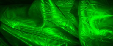 Dönen yaprak desenleri ve hafif yansımalarla vurgulanmış yumuşak kıvrımlı yeşil bir kumaş..