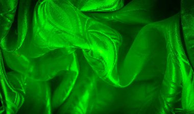 Doğadan esinlenilmiş, ince kıvrımlı ve yumuşak ışıklandırmalı yeşil bir kumaş..