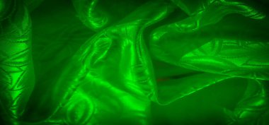 Dalgalı, parlak bir dokusu olan yeşil saten kumaş. Yaprak benzeri desen yumuşak kıvrımlar ve röfle ile vurgulanarak lüks bir görsel yaratıyor.