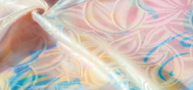 İnce çiçek desenleri ve parlak bir dokusu olan pastel renkli ipek kumaş, yumuşak dalgalar halinde katlanmış, mavi, pembe ve şeftali renginde ışığı yansıtıyor..