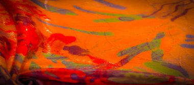 Canlı turuncu, kırmızı ve mor renkli yumuşak, akışkan bir kumaşın yakın çekimi soyut ve dinamik bir deseni ve karmaşık kıvrımları gösteriyor..