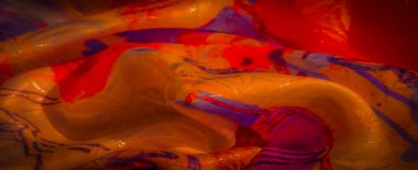 Turuncu, kırmızı ve mor kıvrımlı canlı, ipeksi bir kumaşın yakın çekimi, narin dokusunu ve kıvrımlarını yakalıyor..