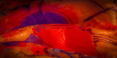 Akan, soyut kumaş tasarımının portakal, mor ve sarı renkli koyu lekeli yakın plan görüntüsü..