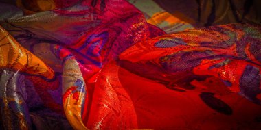 Soyut ve renkli kumaşlar mor, kırmızı, turuncu ve sarı renkli yumuşak ışıklandırmalı ve kıvrımlı..