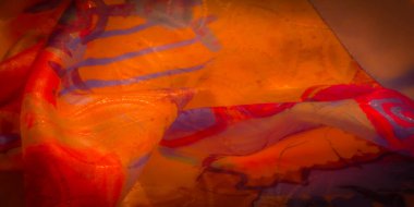 Kırmızı ve turuncu renkli renkli parlak bir kumaş, koyu mavi ve mor vuruşlarla güçlendirilmiş. Sıvı kumaş zarifçe örterek zarif kıvrımlar ve desenler oluşturuyor..