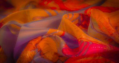 Karmaşık mor, turuncu ve kırmızı desenli zengin, canlı bir kumaş. Yakından bakınca ayrıntılı dokular ortaya çıkıyor, soyut ve akışkan bir kompozisyon oluşturuyor..