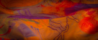 Ilık ışıkla akan ve aydınlatılan, görsel olarak zengin ve soyut bir doku yaratan, karmaşık desenli, canlı, çok renkli bir kumaş..
