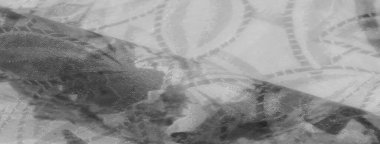 Siyah ve beyaz tonlarında soyut desenleri olan örtülü kumaş yakın plan, doku ve kıvrımları vurguluyor.