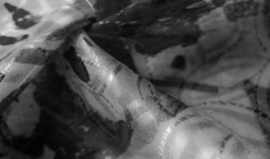 Bu görüntü, kumaşın akış hareketini siyah soyut bir desenle yakalar. Yumuşak doku ve katmanlı kıvrımlar ışık ve gölgenin zengin bir etkileşimini yaratır..