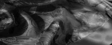 Karmaşık desenleri olan yumuşak ve akışkan bir kumaş. Siyah ve beyaz kompozisyon dokuyu ve ince kıvrımları vurgular..