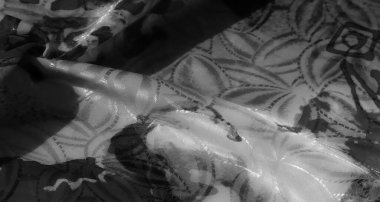 Soyut siyah fırça desenleri ve karmaşık dokuları olan katmanlı bir kumaş, dinamik ve yüksek kontrastlı bir tasarım yaratmak için buruşmuş ve katlanmış..