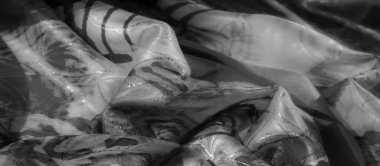 Yumuşak kumaşın soyut siyah ve beyaz desenli yakın çekimi, akıcılığı ve karmaşık tasarımları vurguluyor.