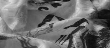 Şeffaf bir tabanda katmanlı siyah desenli kumaş, derinliği ve maddenin içinde hareket duygusunu yakalıyor..