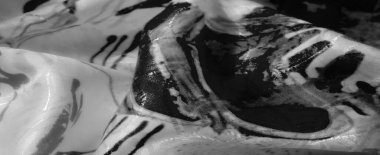 Monokromda karmaşık soyut desenlere sahip kumaş pürüzsüz kıvrımlara ve keskin çizgilere odaklanıyor, dokunsal doğayı vurguluyor ve karmaşık tasarımı vurguluyor..