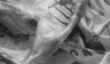 Monokromda karmaşık soyut desenlere sahip kumaş pürüzsüz kıvrımlara ve keskin çizgilere odaklanıyor, dokunsal doğayı vurguluyor ve karmaşık tasarımı vurguluyor..