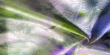 Yeşil, mor ve mavi tonlarında dönen kumaş deseni, saten bir kaplama, soyut, doğadan esinlenilmiş tasarımlar ve gölgeler sergiliyor..