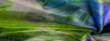 Bu resim kumaş üzerinde yeşil ve mor arasında canlı bir eğilim gösteriyor, yumuşak kıvrımlar ve kumaştan dokuma sanatsal tasarımlar..