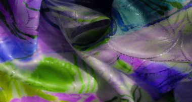 Soyut kıvrımları ve yumuşak dokusu olan zengin yeşil ve mor dinamik bir karışım. Işık ve gölgenin etkileşimi akışkan, renkli bir kumaş tasarımı yaratır..