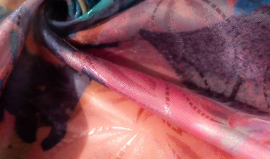 Mavi, sarı, kırmızı ve mor renkli dinamik soyut kumaş baskısı pürüzsüz dokusunu ve zengin sanatsal tasarımını vurgulayan karmaşık kıvrımları gösterir..