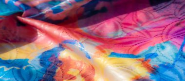 Soyut suluboya desenleri olan, canlı, yakın çekim kıvrımlı, yarı şeffaf bir kumaş, yumuşak mavi, pembe ve sarı eğimli..