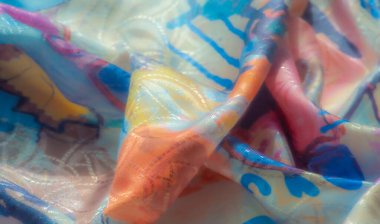 Mavi, sarı ve kırmızıları harmanlayan soyut suluboya desenli canlı bir kumaş. Kumaşın dokusu ve doğal kıvrımları yumuşak ve akıcı bir görünüm yaratır..