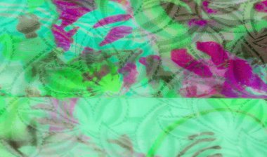 Geniş yeşil ve morumsu bir kumaşın yakın çekimi soyut girdap desenleri ve yumuşak kıvrımları ile dinamik ve dokusal bir yüzey oluşturur..