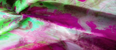 Parlak ve gölgeli yeşil ve pembe desenli kumaş. Karmaşık tasarımlar sergiliyor. Yumuşak, akıcı bir dokusu var..