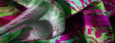 Işık, doku ve hareketin dinamik etkileşimini yaratan yeşil, pembe ve metalik elementlerin yer aldığı, kıvrımları ve kıvrımları olan, canlı, çok renkli, soyut yakın çekimler..