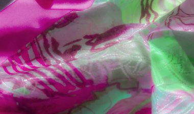 Kumaş, pembe ve yeşilin baskın olduğu, doku ve canlılık hissi veren soyut tasarımlar içeriyor..