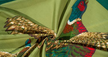 Yeşil kumaş üzerine basılmış, uçan sülünlerin canlı bir çizimi. Altının tonları, kırmızı, yeşil ve mavi renkli tüyler pürüzsüz arka planda..