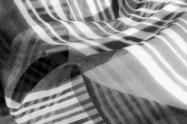 Sıvı dikey çizgileri olan hassas bir kumaşın yakın çekimi, minimalist gri tonlama paletinde yumuşak bir eğim etkisi yaratır..