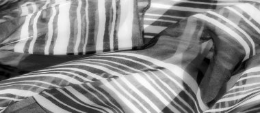 Karmaşık akış çizgileriyle pürüzsüz bir kumaş yüzeyi yumuşak kıvrımlara ve kıvrımlara karışıp soyut ve sanatsal çekiciliğini artırıyor..