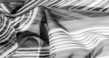 Akışkan dalgaları ve yumuşak kıvrımları olan gri pullu bir kumaş, dinamik ama yatıştırıcı bir görsel etki yaratıyor, akışkan doğasıyla gelişiyor..