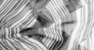 Akışkan dalgaları ve yumuşak kıvrımları olan gri pullu bir kumaş, dinamik ama yatıştırıcı bir görsel etki yaratıyor, akışkan doğasıyla gelişiyor..