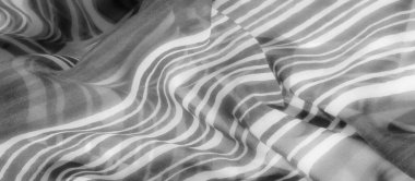 Akışkan dalgaları ve yumuşak kıvrımları olan gri pullu bir kumaş, dinamik ama yatıştırıcı bir görsel etki yaratıyor, akışkan doğasıyla gelişiyor..