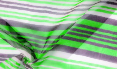 Yumuşak kıvrımlar derinlik ve doku oluşturan yeşil, gri ve beyaz çizgilerle akan kumaşın yakın çekim görüntüsü. Kumaşlar pürüzsüz yüzey ve dinamik hareket ona modern, şık bir cazibe verir..