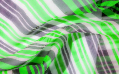 Yemyeşil, beyaz ve gri çizgilerden oluşan canlı bir kumaş deseni malzemeyi karıştırıp dokuyor ve dinamik ve akışkan bir etki yaratıyor..