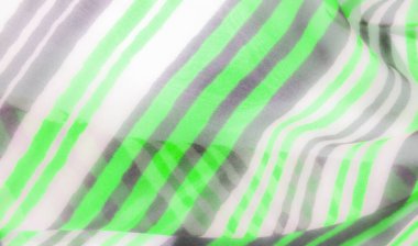 Alternatif yeşil, beyaz ve gri çizgileri olan hafif, dalgalı bir kumaşın çarpıcı yakın çekimi. Kumaş yumuşak kıvrımlar ve kırışıklıklar yaratır, çizgilerin ve renklerin dinamik modelini geliştirir..