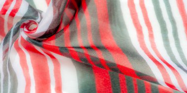 Bu resim kırmızı, siyah ve beyaz desenli çarpıcı çizgili bir kumaş yakalar. Işık ve gölge oyunu canlı renkleri arttırır ve kumaşların dokulu yüzeyine derinlik katar.