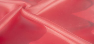Bu canlı yakın çekim yumuşak ve dinamik bir kıvrım yaratan kırmızı renkli kumaş ve gölgelerin pürüzsüz ve akışkan dokusunu sergiliyor. İpeksi yüzey lüks bir his veriyor.,