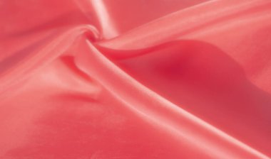 Kırmızı kumaştan çarpıcı bir yakın çekim, pürüzsüz dokusunu ve narin kıvrımlarını yakalıyor. Parlak kırmızı renk ve ince parıltı lüks ve zarif bir his yaratır..