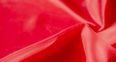Yumuşak, sıvı kıvrımlı, yumuşak kırmızı kumaştan çarpıcı bir makro çekim derinlik ve boyut yaratır. Işık ve gölgenin etkileşimi canlı kırmızı renkleri güçlendirir.,